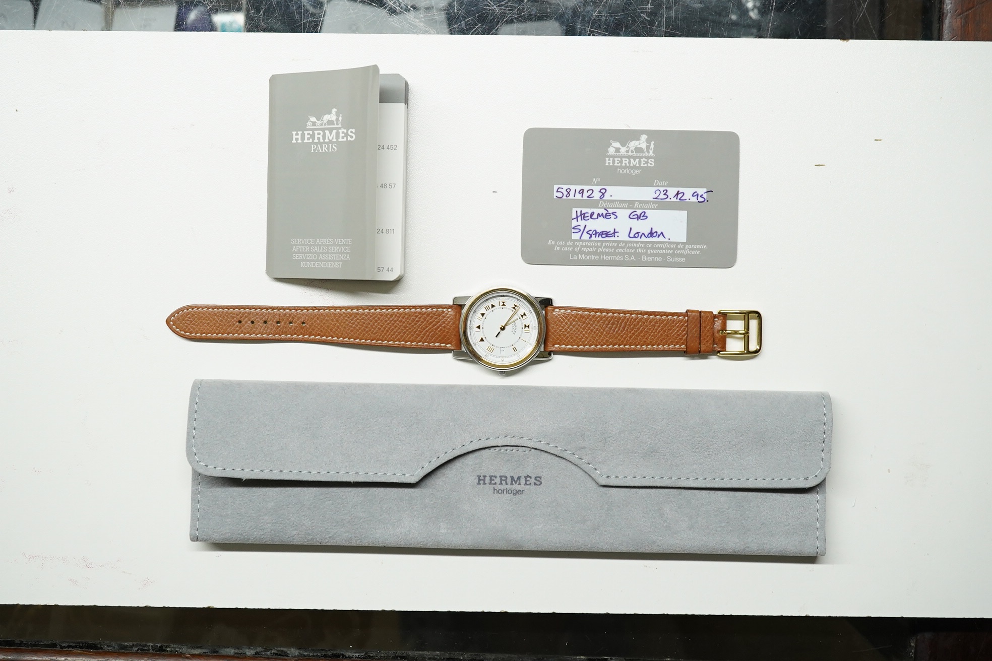 A gentleman's 1990's steel and gold plated Hermes quartz wrist watch, with Roman dial and date aperture, on a Hermes leather strap, with box and certificate, case diameter 34mm. Condition - good